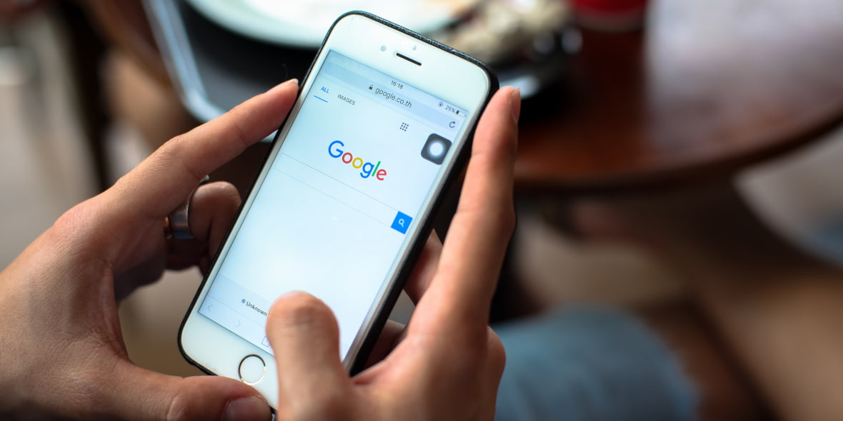 Person Using Google Search Engine on an iPhone Person Using Google Search Engine on an iPhone