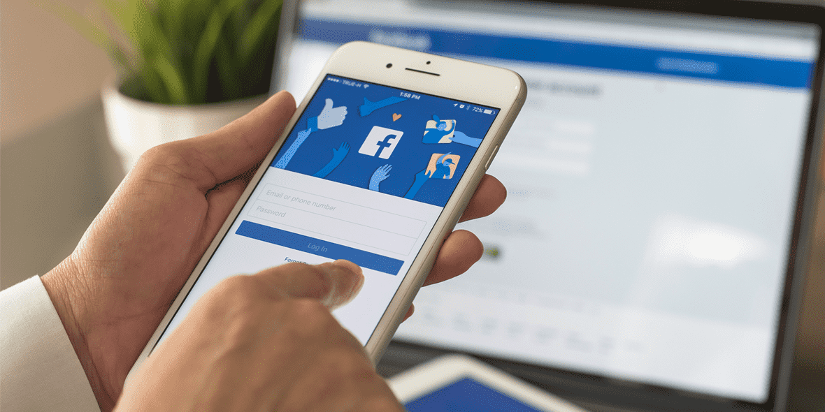 Person logging into the Facebook app on mobile Person logging into the Facebook app on mobile