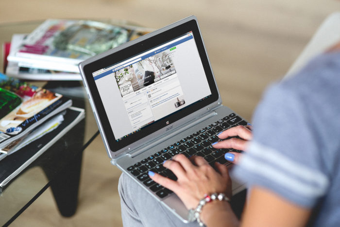 Person using Facebook on laptop