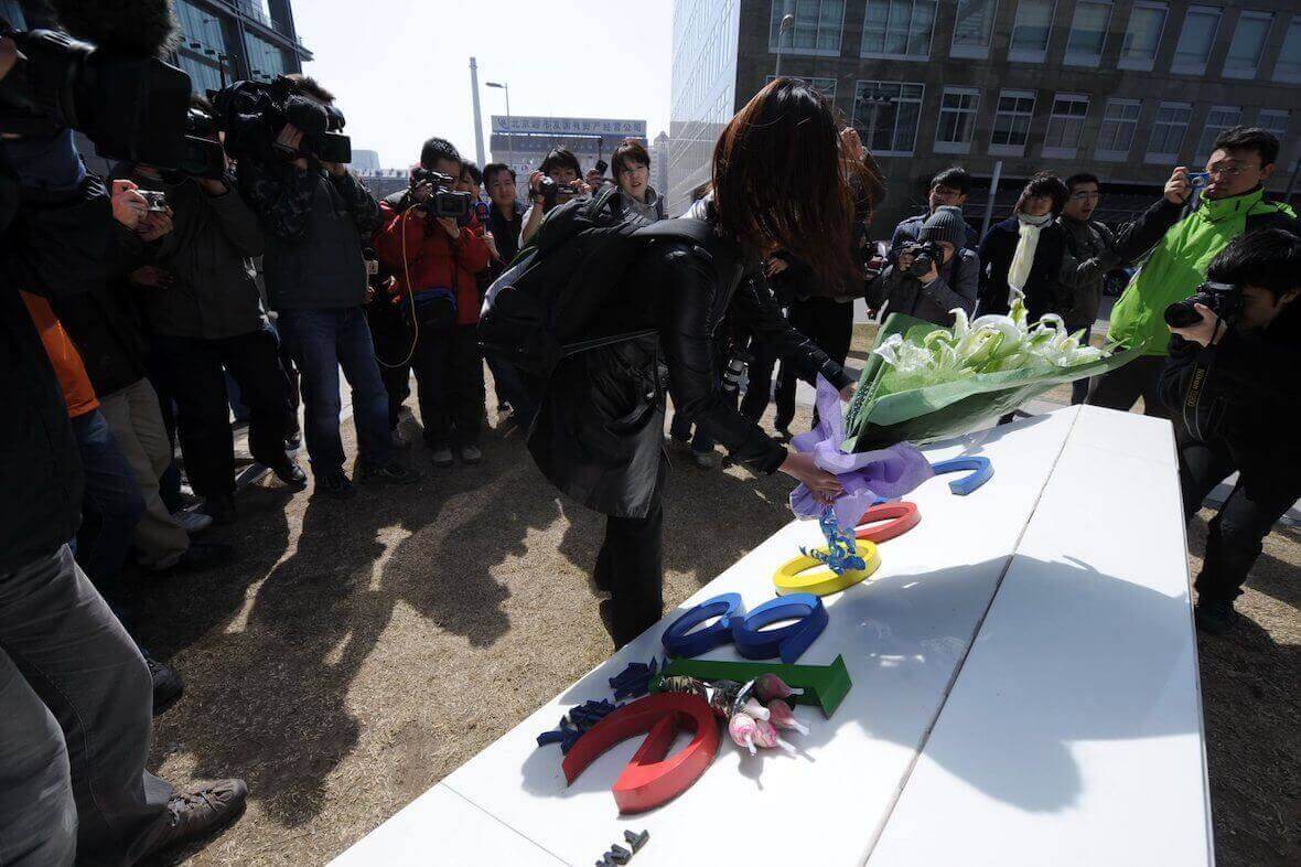 A woman lays flowers on the sign for Google's offices in China