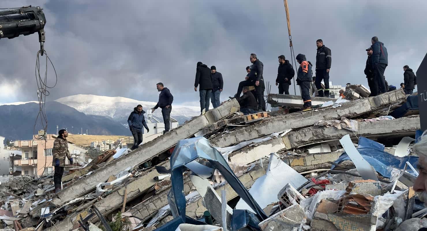 Emergency teams search for survivors in the rubble of a destroyed building, in Iskenderun, Turkey