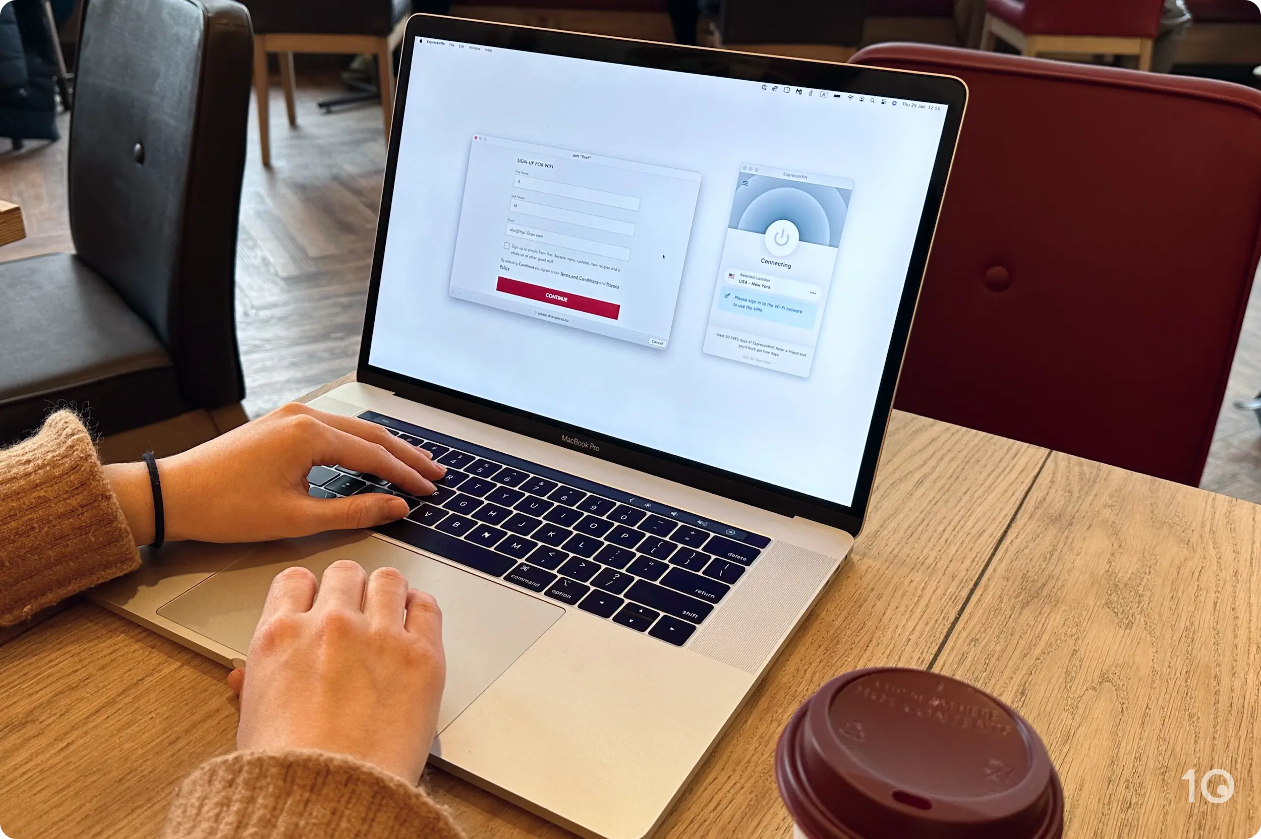 In a coffee shop, using a MacBook to connect to public WiFi with ExpressVPN. 